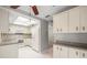 Bright kitchen featuring tile flooring, white appliances, and ample cabinet space at 3066 Landmark Blvd # 1305, Palm Harbor, FL 34684