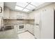 Well-lit kitchen with white appliances, cabinetry, and a tile backsplash at 3066 Landmark Blvd # 1305, Palm Harbor, FL 34684