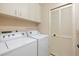 This laundry room includes a side-by-side washer and dryer, plus storage cabinets at 3066 Landmark Blvd # 1305, Palm Harbor, FL 34684