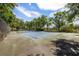 Enjoy a friendly match on the community tennis court, surrounded by mature trees and a secure fence at 3066 Landmark Blvd # 1305, Palm Harbor, FL 34684