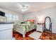 Comfortable bedroom with ceiling fan, bedside table and decorative full-length mirror at 3122 37Th S Ln # C, St Petersburg, FL 33711