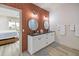 Modern bathroom with double vanity, brick accent wall, and elegant lighting at 3174 Sanibel Dr, Hernando Beach, FL 34607