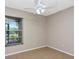 A sunlit bedroom showcases a ceiling fan and window with blinds for a cozy atmosphere at 3455 Countryside Blvd # 31, Clearwater, FL 33761