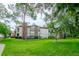 Exterior of a multi-story condo building surrounded by lush greenery and a well-manicured lawn at 3455 Countryside Blvd # 31, Clearwater, FL 33761