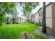 Exterior view of a multi-story condo building with well-maintained lawn and mature trees at 3455 Countryside Blvd # 31, Clearwater, FL 33761