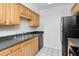 Classic kitchen design featuring black appliances, light wood cabinets, and stainless steel double sink at 3455 Countryside Blvd # 31, Clearwater, FL 33761