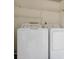 Convenient laundry area equipped with a washing machine, dryer, and shelving at 3455 Countryside Blvd # 31, Clearwater, FL 33761