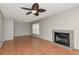 Open living room featuring wood floors, a ceiling fan, large window, and a cozy fireplace at 3455 Countryside Blvd # 31, Clearwater, FL 33761