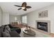 Cozy living room with wood floors, fireplace, modern ceiling fan, and dining area at 3455 Countryside Blvd # 31, Clearwater, FL 33761