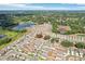 A beautiful aerial view of a neighborhood with well-maintained homes, a serene lake, and lush green landscapes at 36557 Night Strawberry Ct, Dade City, FL 33525