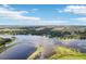 A stunning aerial view of a lake and natural landscape under a blue sky with scattered clouds at 36557 Night Strawberry Ct, Dade City, FL 33525