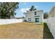 A large backyard features a white fence, a grassy area, and a view of the two-story home at 36557 Night Strawberry Ct, Dade City, FL 33525