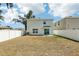 Backyard with white fence, showing home's exterior with sliding glass door and green space at 36557 Night Strawberry Ct, Dade City, FL 33525