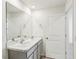 Bathroom featuring a double sink vanity with a large mirror, white cabinets, and bright white walls at 36557 Night Strawberry Ct, Dade City, FL 33525