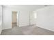 Spacious bedroom with neutral carpet, white trim, and multiple doors for convenient access at 36557 Night Strawberry Ct, Dade City, FL 33525