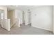 Upstairs hallway featuring neutral carpet, white walls, multiple doorways, and access to a small staircase at 36557 Night Strawberry Ct, Dade City, FL 33525