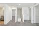 Neutral upstairs hallway featuring grey carpet, white walls, half wall, and access to the bathroom and bedroom at 36557 Night Strawberry Ct, Dade City, FL 33525