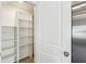 Pantry with organized shelving, adjacent to the refrigerator, offering ample storage space at 36557 Night Strawberry Ct, Dade City, FL 33525