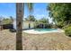 Backyard featuring a pool, screened patio, a large tree, and partial fencing at 3719 Greenford St, Valrico, FL 33596