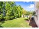 Lush backyard featuring mature trees and green grass, providing a private and serene outdoor space at 4407 Scarlet Loop, Wesley Chapel, FL 33544