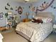 Cozy bedroom featuring a queen bed, shelving, and cheerful decor at 4407 Scarlet Loop, Wesley Chapel, FL 33544