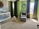 Bright Bedroom with a crib, chair, and birch-themed wallpaper at 4407 Scarlet Loop, Wesley Chapel, FL 33544