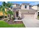 Charming two-story home featuring stone accents, a two-car garage, and lush landscaping at 4407 Scarlet Loop, Wesley Chapel, FL 33544