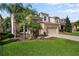 Two-story home showcasing stone accents, lush greenery, and a convenient two-car garage at 4407 Scarlet Loop, Wesley Chapel, FL 33544