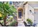 Inviting entryway with a stone archway, dark front door, and well-maintained landscaping at 4407 Scarlet Loop, Wesley Chapel, FL 33544