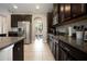 Bright kitchen with dark cabinets, stainless steel appliances, granite countertops, and views to the backyard at 4407 Scarlet Loop, Wesley Chapel, FL 33544