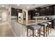 Spacious kitchen features an island with granite countertops, stainless steel appliances, and dark wood cabinetry at 4407 Scarlet Loop, Wesley Chapel, FL 33544