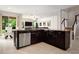 Open-concept kitchen boasts dark wood cabinets, stainless steel appliances, granite countertops and opens to living area at 4407 Scarlet Loop, Wesley Chapel, FL 33544