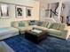 Comfortable living room features a sectional sofa, patterned rug, ottoman, and staircase access at 4407 Scarlet Loop, Wesley Chapel, FL 33544