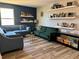 This modern living room features floating shelves, beautiful furniture and luxury vinyl plank floors at 4407 Scarlet Loop, Wesley Chapel, FL 33544