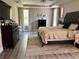 This bedroom features a spacious layout, wood floors, a tray ceiling, neutral paint and a decorative area rug at 4407 Scarlet Loop, Wesley Chapel, FL 33544