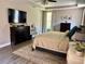 Serene main bedroom features wood floors, neutral colors, large windows, and a tray ceiling at 4407 Scarlet Loop, Wesley Chapel, FL 33544