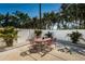 Backyard patio featuring an outdoor dining set, white fencing, and tropical landscaping at 451 27Th N Ave, St Petersburg, FL 33704