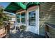 A view of the front porch with white table and chairs outside the front door and window at 451 27Th N Ave, St Petersburg, FL 33704