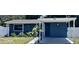 Well-maintained blue house with a carport, landscaped lawn, and clear house number at 4516 W Paxton Ave, Tampa, FL 33611