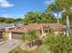 An aerial view showcases the property's manicured lawn, palm trees, and proximity to mature trees at 4519 Swallowtail Dr, New Port Richey, FL 34653