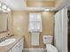Cozy bathroom featuring a sink vanity, toilet, and window for natural light at 4519 Swallowtail Dr, New Port Richey, FL 34653