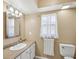 Bathroom features a sink vanity, toilet, and a window for natural lighting at 4519 Swallowtail Dr, New Port Richey, FL 34653