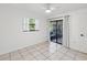 Light-filled bedroom with tile floors, a ceiling fan, window, and sliding glass doors to the outdoor patio at 4519 Swallowtail Dr, New Port Richey, FL 34653
