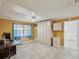 Bright bedroom featuring neutral tile floor, large closet space, and a dedicated workstation or vanity area at 4519 Swallowtail Dr, New Port Richey, FL 34653