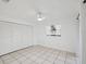 Bright bedroom featuring white walls, tile flooring, a ceiling fan, and a window for natural light at 4519 Swallowtail Dr, New Port Richey, FL 34653