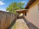 Home exterior featuring a covered storage area and a wood fence at 4519 Swallowtail Dr, New Port Richey, FL 34653