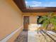 A front entrance with a brown decorative front door, stucco walls, and manicured plants at 4519 Swallowtail Dr, New Port Richey, FL 34653