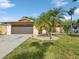 Charming single-story home showcasing lush landscaping, a well-manicured lawn, and a two-car garage at 4519 Swallowtail Dr, New Port Richey, FL 34653