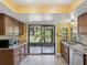 Kitchen with stainless appliances, tile countertops, and sliding glass doors to the screened-in patio at 4519 Swallowtail Dr, New Port Richey, FL 34653