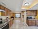 Fully equipped kitchen with wood cabinets, stone counters, stainless appliances and view into adjoined living space at 4519 Swallowtail Dr, New Port Richey, FL 34653